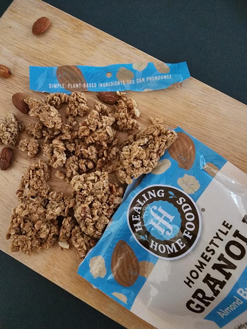 Healing Home Foods homestyle granola on a wooden board with packaging.