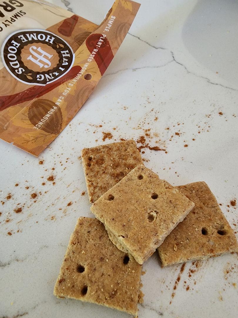 Three crackers on a marble surface with a package of crackers in the background.