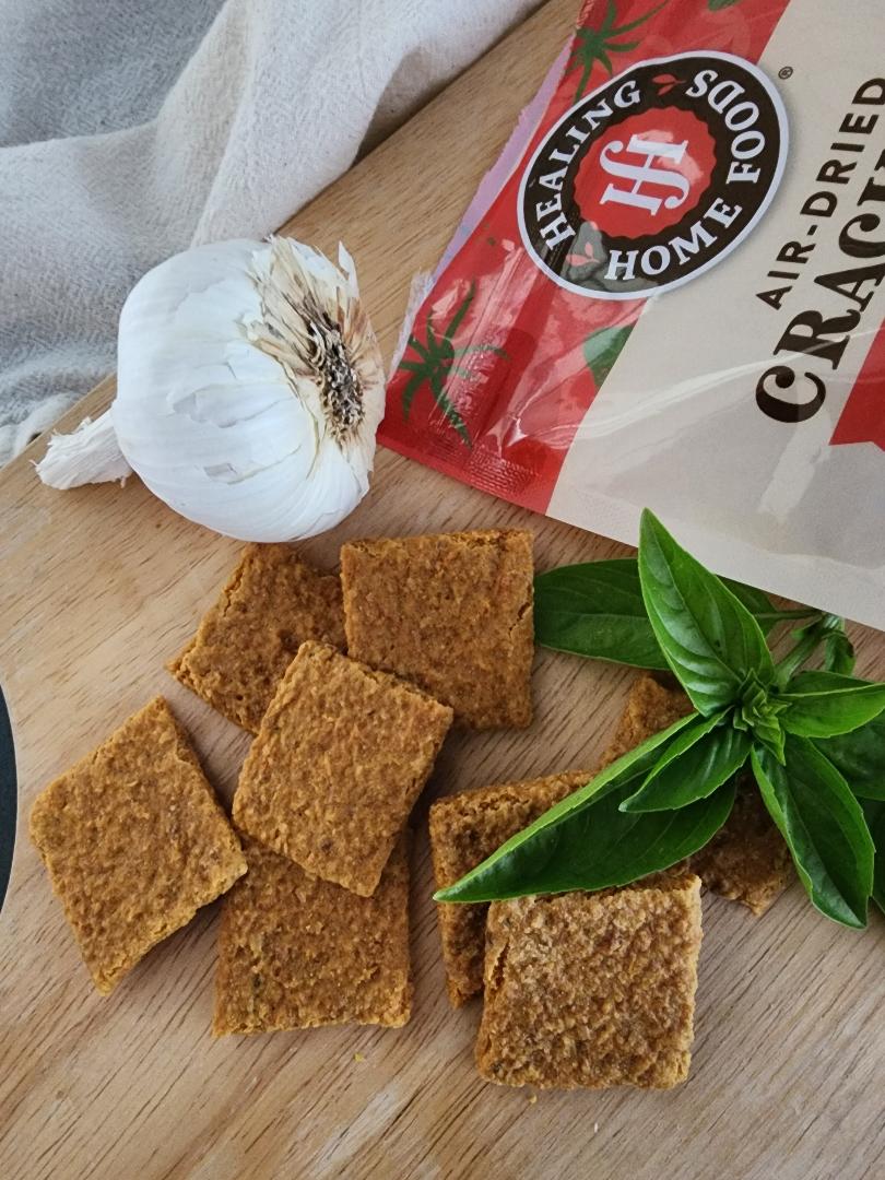 Healing Hands Home Foods crackers on a wooden board with garlic and basil